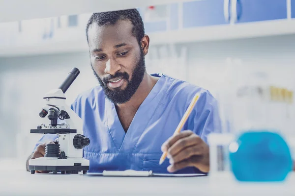 보고서를 작성 하는 파란색 유니폼에 젊은 생물학 — 스톡 사진