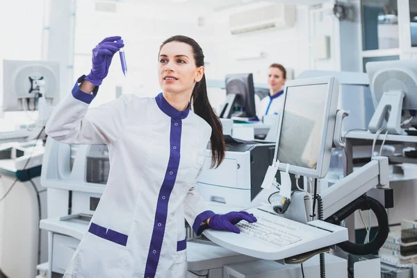 Trabalhador médico encantado examinando reagente — Fotografia de Stock