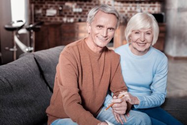 Kanepede oturan neşeli olgun insanlar