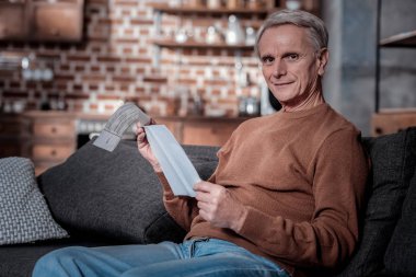 Doğruca kameraya bakan memnun gri saçlı adam