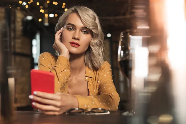 Charmig ung kvinna poserar sittande på bar och textning — Stockfoto