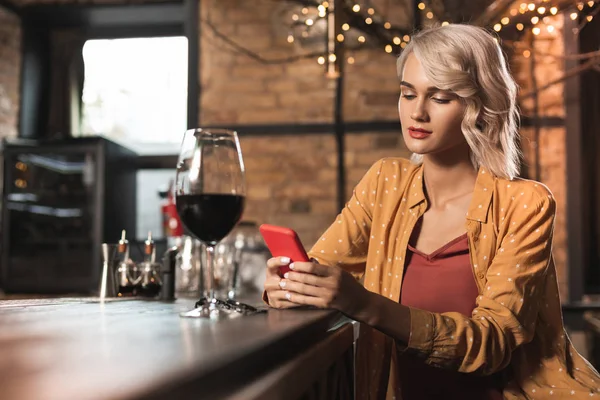 Agradable joven mujer navegando por Internet mientras bebe en el bar —  Fotos de Stock