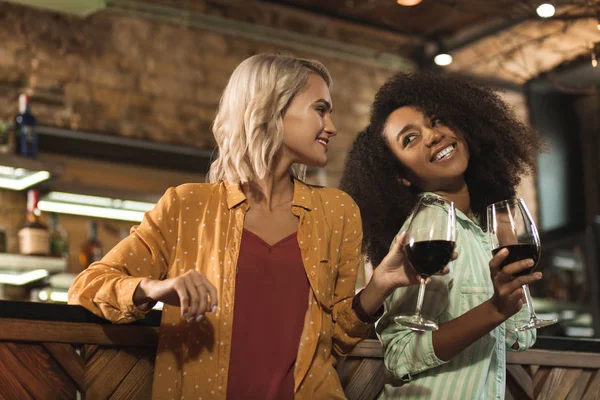 Alegre amigas bebiendo vino en el bar — Foto de Stock