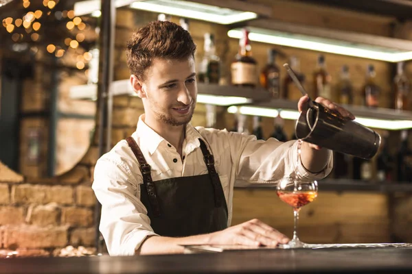Yakışıklı genç barmen bir kokteyl yapmak — Stok fotoğraf