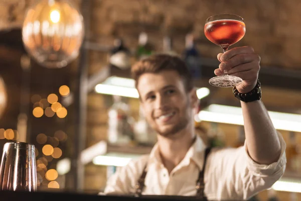 Trevlig ung bartender kontrollera kvaliteten på cocktail — Stockfoto