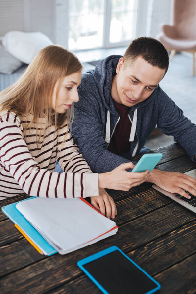 Серьезная девушка показывает фотографии своему парню
