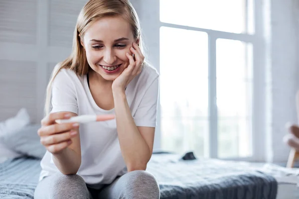 Mujer inspirada sosteniendo su prueba de embarazo —  Fotos de Stock