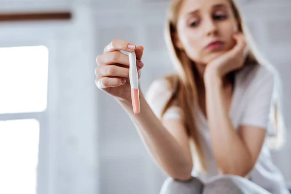 Mujer concentrada sosteniendo su prueba de embarazo — Foto de Stock