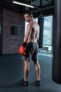 Boks eldivenleri ve siyah spor ayakkabı giyen esmer atlet