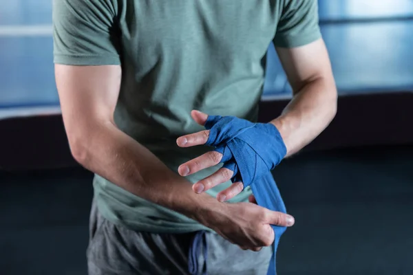 Muscle man rolling his hands in wrist wraps before training — Stock Photo, Image