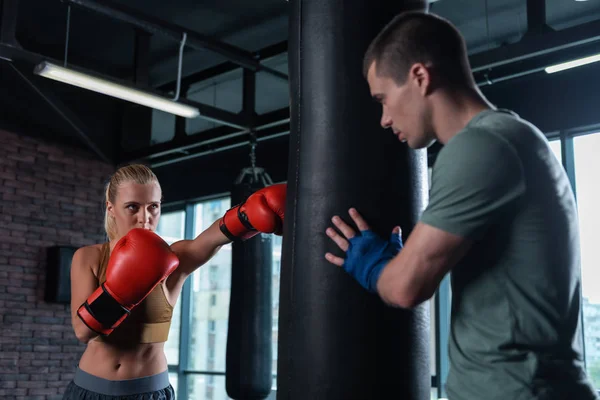 Blonde-haired female boxer coming to gym for working with trainer — Stock Photo, Image