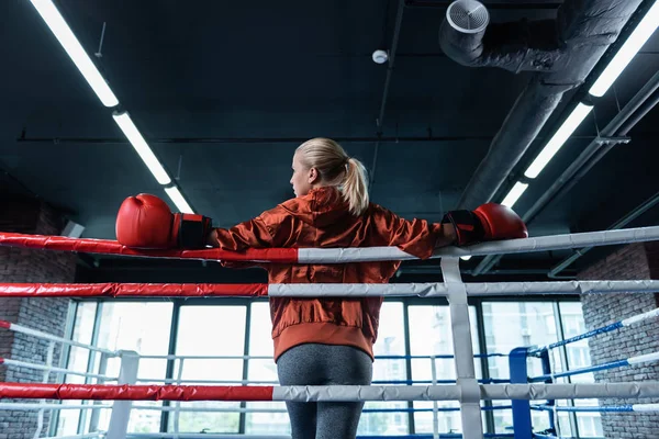 Boxeador femenino de pelo rubio con leggins grises y chaqueta deportiva roja — Foto de Stock