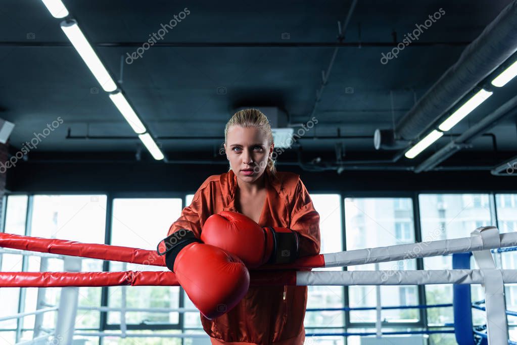 Blonde-haired female boxer standing in boxing ring