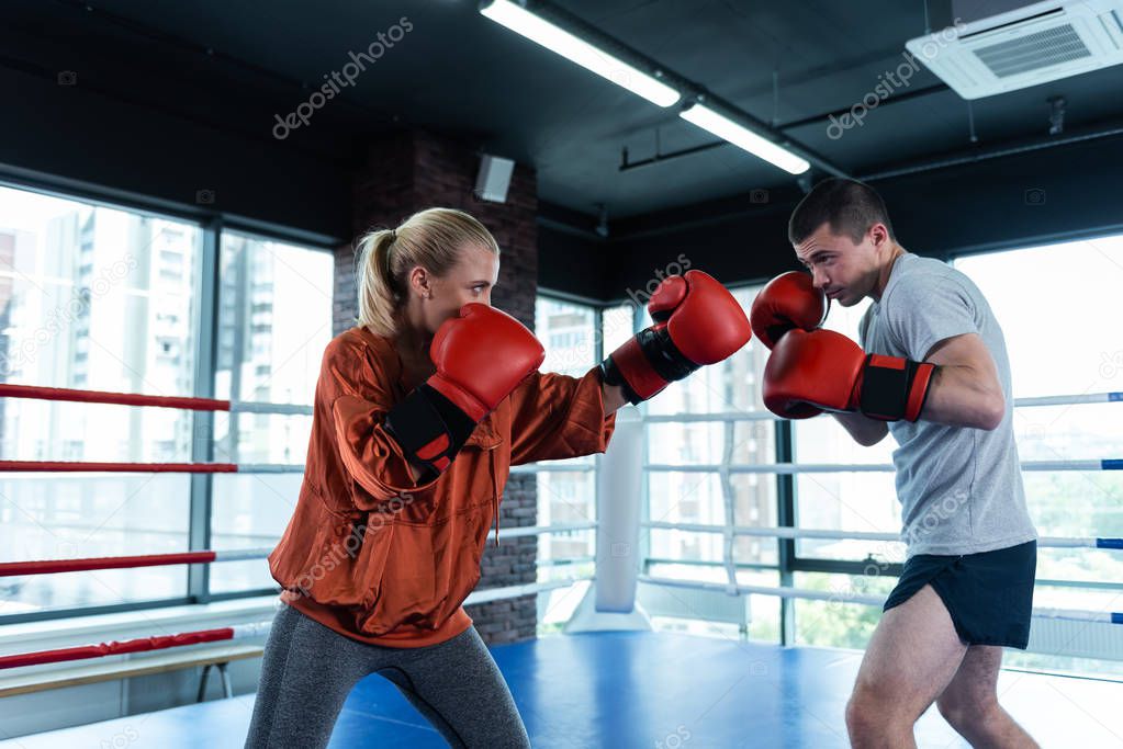 Female blonde-haired boxer training before competition