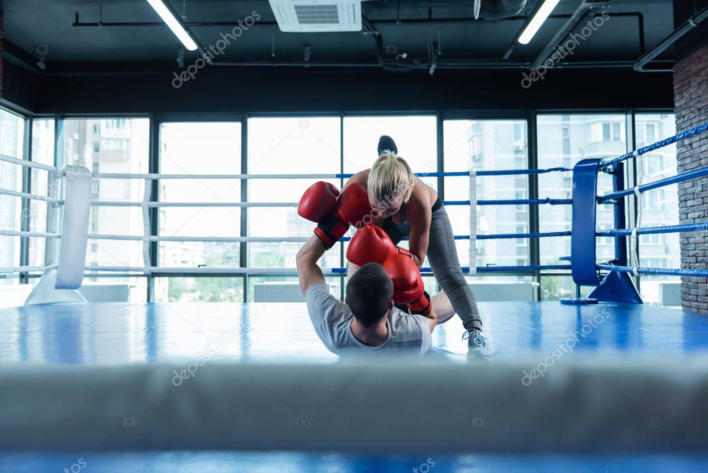 Blonde-haired female boxer fighting her old friend in gym