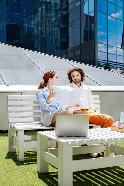 Handsome curly man sitting near his appealing girlfriend