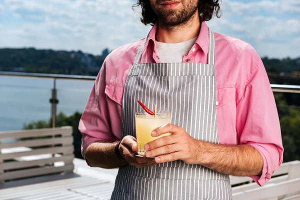 Bearded long-haired waiter providing service for his clients