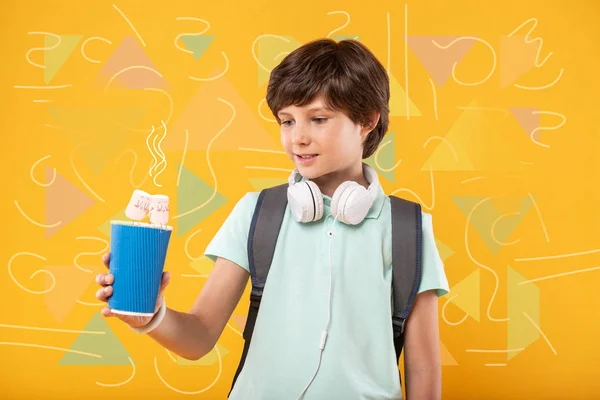 Ragazzo sorridente guardando il suo drink e pensando — Foto Stock