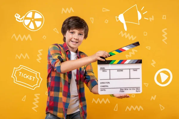 10 代の少年、clapstick を押しながらアマチュア映画を作る — ストック写真