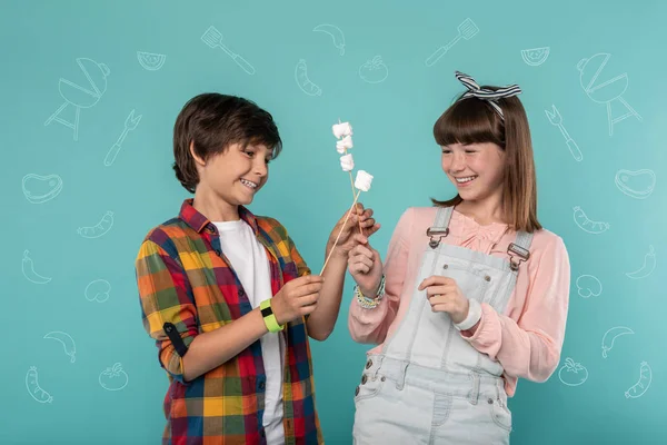 Bambini felici godendo la loro gita scolastica e mangiare marshmallows — Foto Stock