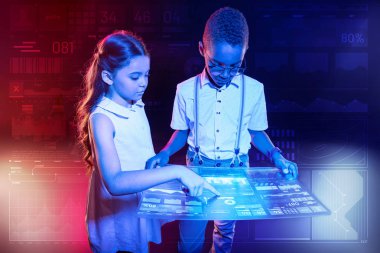 Akıllı çocuklar büyük bir tablet tutan ve bu ekranına işaret