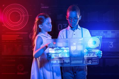 Dikkatli çocuk yumuşak şeffaf aygıt ve arkadaşı ona işaret tutan