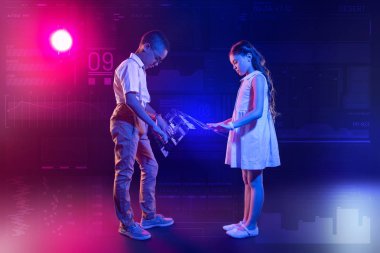 Karşılıklı duran ve holografik ekran dokunaklı sakin çocuklar