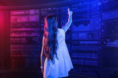 Uzun saçlı kız yukarı ve şeffaf bir ekran dokunaklı elini koyarak