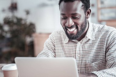 Netbook ekrana bakarak mutlu neşeli adam