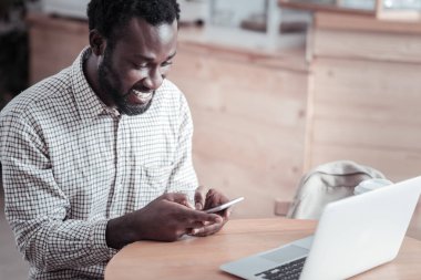 Neşeli genç adam onun smartphone kullanarak