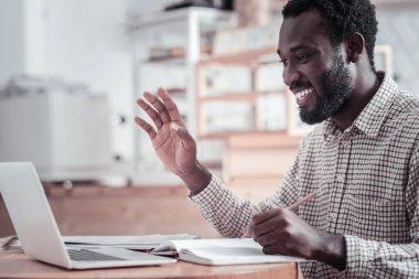 Mesafe iletişim. Onun netbook önünde oturan ve okurken onun arkadaşı tebrik mutlu güzel yakışıklı adam