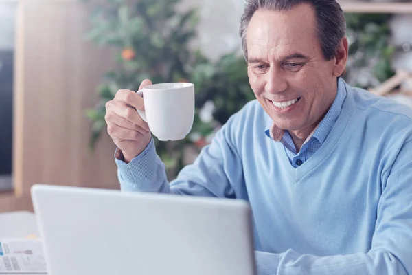 Fröhlicher positiver Mann genießt seinen Kaffee — Stockfoto