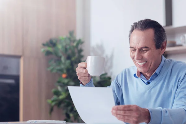 Feliz hombre encantado sosteniendo una taza de café — Foto de Stock