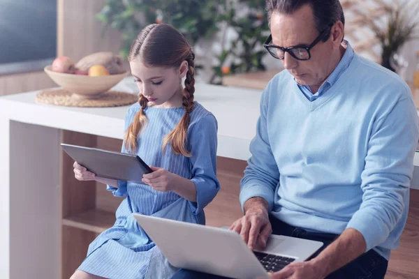 Nice serious father and daughter sitting together — Stock Photo, Image