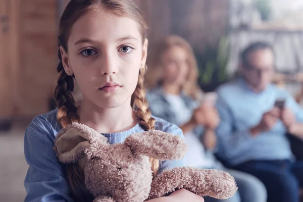 Upset young girl hugging her fluffy toy