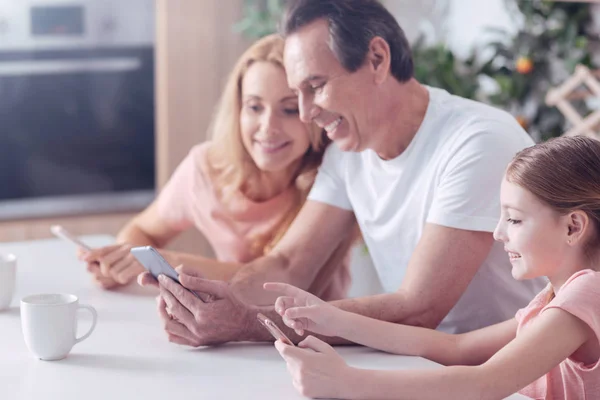 Vrolijke positieve familie elkaar zitten — Stockfoto