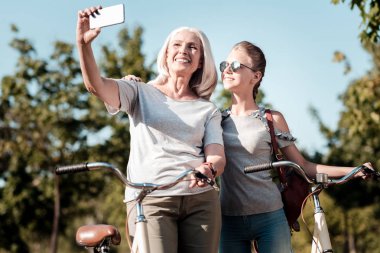 Modern Büyükanne sağ elinde telefon ile yetiştirme