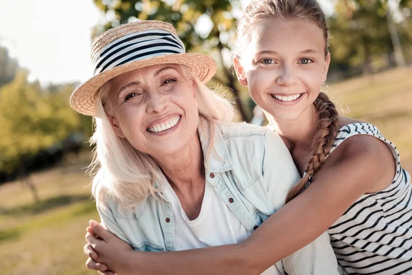 Freudiges Mädchen umarmt ihre glückliche Oma — Stockfoto