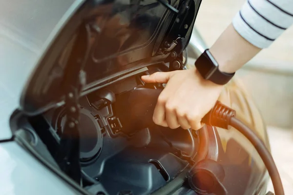 Carga de un coche eléctrico ecológico buscando muy fácil —  Fotos de Stock