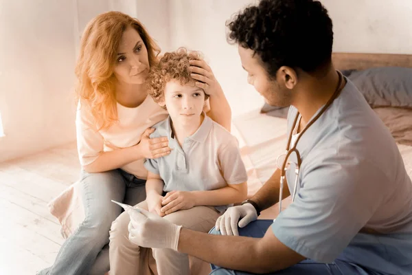 Worried female listening to doctor of her kid — Stock Photo, Image
