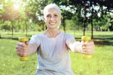 Neşeli emekli sarı el ağırlıkları ile egzersiz