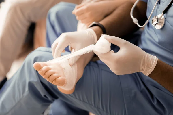 Professional medical worker dressing little foot — Stock Photo, Image