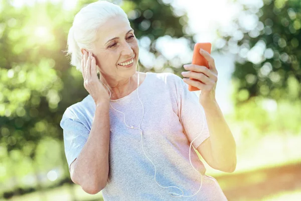 Pensionista enérgica progresiva usando su teléfono inteligente — Foto de Stock