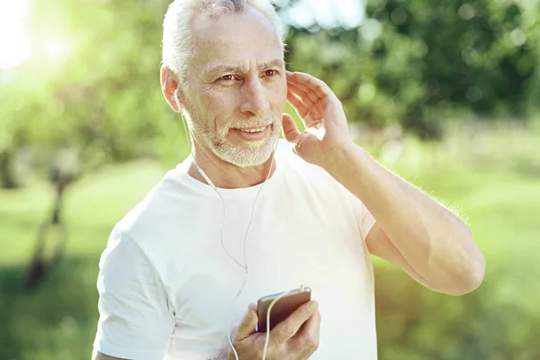 Homem idoso excitado usando fones de ouvido — Fotografia de Stock