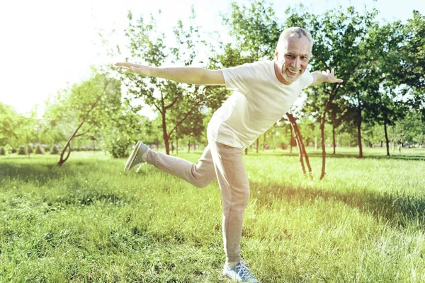 Веселый пожилой мужчина наслаждается забавными упражнениями — стоковое фото