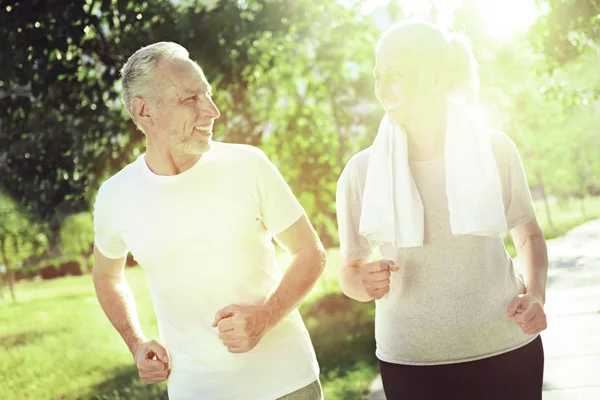 Adorable active senior people running in a park