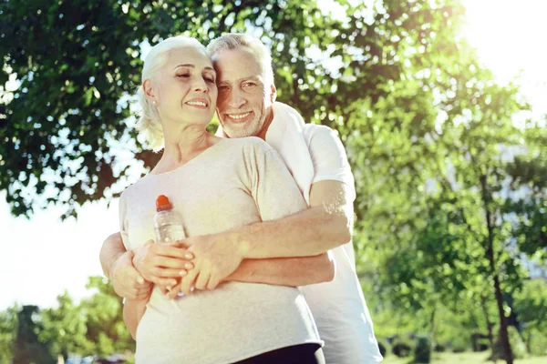 Adorable pareja de ancianos abrazándose en un parque — Foto de Stock