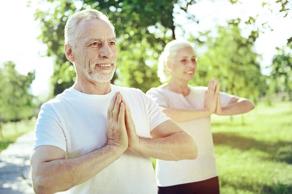 Healthy aged people practicing yoga together