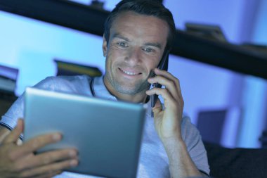 Tablet ekrana bakarak olumlu neşeli adam