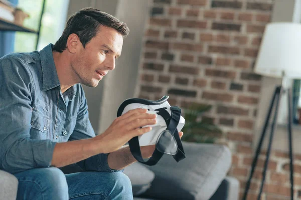 Pleasant excited man studying new technologies